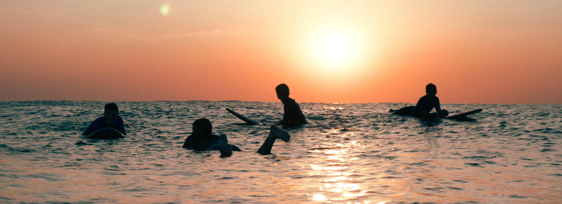 Junior surfers Spain sunset